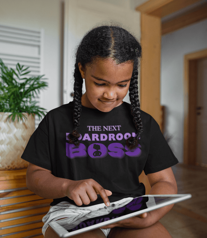 Young girl reading while wearing purple and black Inspirational children’s T-shirt celebrating ambition and self-confidence from TL Johnson Stories.