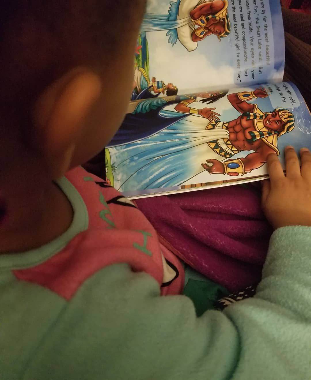 Young girl reading Nefertiti & The Great Lake  (Mini Monarchs #1).