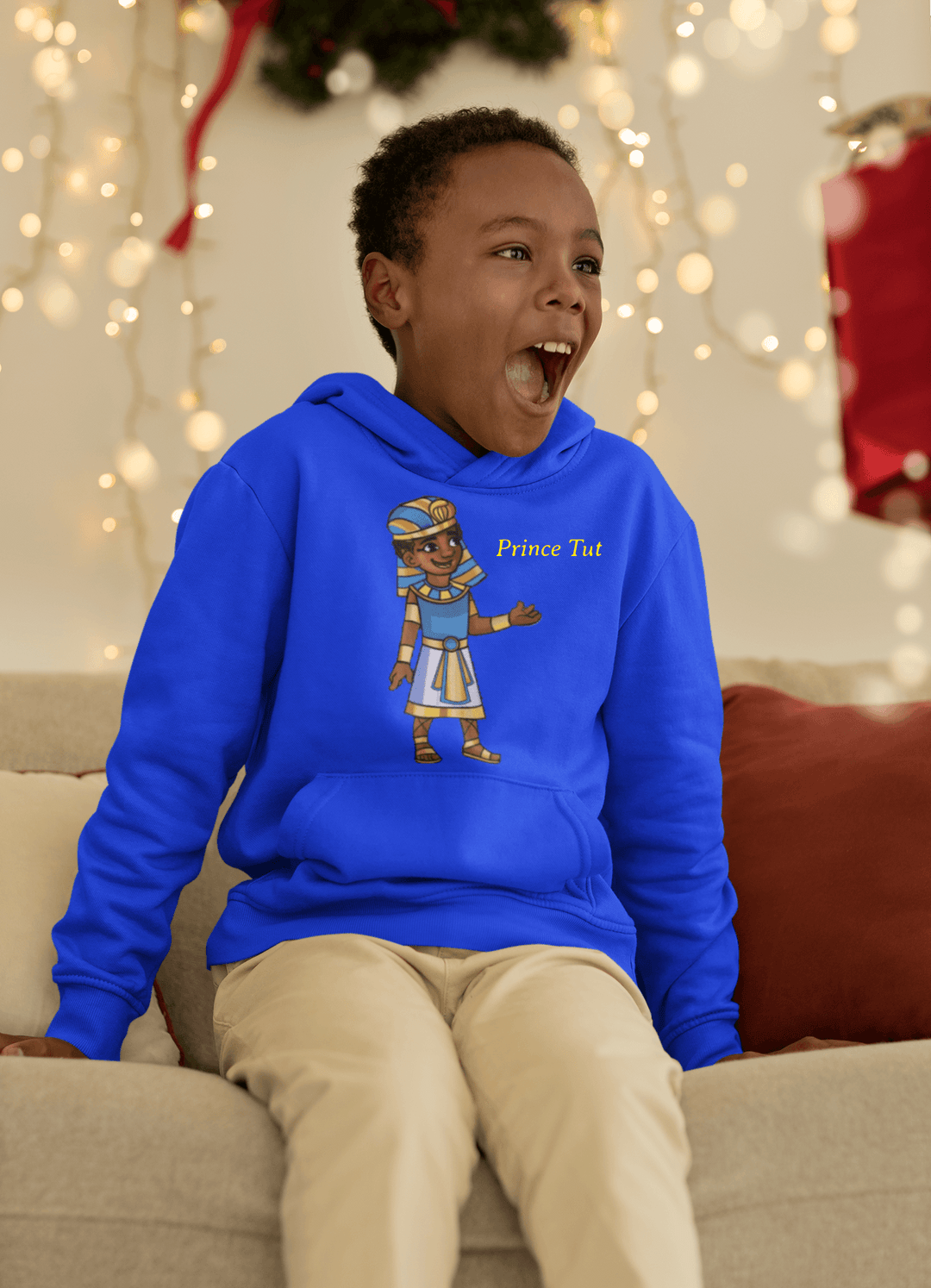 Black boy wearing Blue Tut “Lead With Wisdom” hoodie inspired by TL Johnson’s Mini Monarchs Universe; African royalty design symbolizing wisdom and leadership.