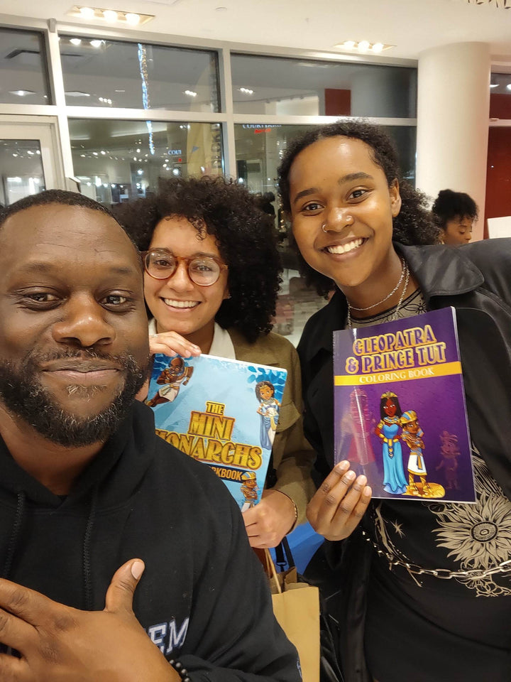 Tow young ladies with the creator one is holding The Mini Monarchs Activity Book. the other is holding Cleopatra & Tut Coloring Book.